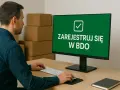 Mężczyzna przy biurku rejestruje jednoosobową działalność gospodarczą a śmieci w systemie BDO.