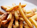 En hög med gyllene, krispiga pommes frites, strödda med örter och havssalt. Perfekt för en mysig hemmakväll.