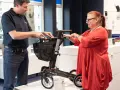 Mann erklärt einer Frau einen Rollator, ein wichtiges medizinisches Hilfsmittel, im Sanitätshaus.
