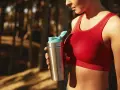 En kvinna i röd sporttopp håller en proteinshaker. Frågan om hur mycket protein kan kroppen ta upp är relevant för hennes träning.