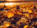 Bursztyny na plaży w Łebie, niczym skarby z muzeum bursztynu, lśnią w złotym świetle zachodzącego słońca.