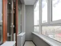 Wnętrze loggii z widokiem na miasto. Drewniane drzwi i okna wychodzą na zewnątrz.