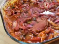 Pyszna karkówka po cygańsku w sosie pomidorowym z cebulą i papryką, zapiekana w szklanym naczyniu.