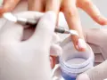 Zabieg paznokci tytanowych może prowadzić do osłabienia płytki. Widać tu aplikację produktu, która może być przyczyną wad.