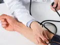 Lekarz mierzy ciśnienie krwi pacjentowi. Jeśli zastanawiasz się, jak szybko podnieść ciśnienie krwi, konsultacja lekarska jest kluczowa.