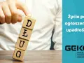 Ręka przewraca kostki z napisem "DŁUG". Życie po ogłoszeniu upadłości konsumenckiej to szansa na nowy start.