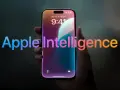 Dłoń trzyma smartfon z ekranem blokady, na którym widnieje napis "Apple Intelligence" w tęczowych barwach.