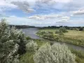 Malowniczy krajobraz z rzeką i zielonymi wzgórzami, idealny na sandomierz trasy rowerowe.
