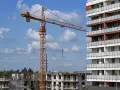 Plac budowy, gdzie lex deweloper wznosi nowoczesne apartamenty. Widoczny dźwig budowlany i postępujące prace.