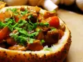 Gulasz z polędwiczki wieprzowej w chlebie, posypany natką pietruszki. Pyszne danie, które zachwyca smakiem.