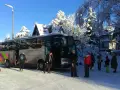 Grupa turystów wysiada z autobusu w zimowej scenerii. To **białka tatrzańska termy trasa** – idealne miejsce na zimowy wypoczynek.