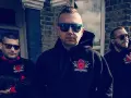Trzech mężczyzn w bluzach z logo "Gang Albanii". Jeden z nich pokazuje gest ręką.