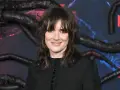 Winona Ryder, gwiazda filmów i seriali, w tym "Stranger Things", na tle dekoracji z mackami i logo Netflix.