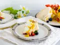 Porción de pavlova con fresas, arándanos y mango, bañada en salsa de maracuyá. Los pavlova ingredientes son visibles en este postre.
