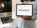 Wczesna ciąża, 2 tydzień. USG pokazuje zarodek, a na tablecie widnieje napis "PREGNANCY".