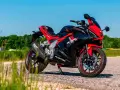 Czarny sportowy motocykl Barton Blade R 125 V Max z czerwonymi akcentami, zaparkowany na drodze w słoneczny dzień.