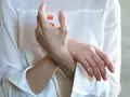 En person håller sin handled, möjligen på grund av inflammation i senskidan.