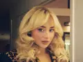 Frau mit voluminösem blondem Haar und Leopardenmuster-Jacke.