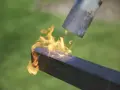 Application de la flamme sur un bois brulé japonais pour le protéger.