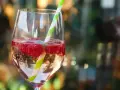 Orzeźwiający drink z bacardi malinowym, z bąbelkami i malinami, ozdobiony słomką.