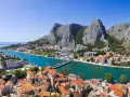 Widok na miasto Omiš w Chorwacji, gdzie rzeka Cetina wpada do morza. Piękne, turkusowe morze i góry.