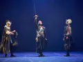 Tres hombres con armadura y espadas en un escenario. El del centro levanta su espada. Escena de "El alcalde de Zalamea".