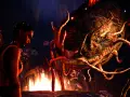 Kobieta patrzy na potwora w mrocznym lesie. To scena z gry "South of Midnight", gdzie magia i niebezpieczeństwo splatają się w nocnej przygodzie.