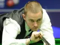 Gracz snookera w skupieniu celuje kijem do bili. Czy to on zostanie mistrzem świata w snookerze 2025?