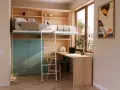Solución inteligente para habitaciones pequeñas juveniles: cama elevada, escritorio y armarios integrados en madera clara y verde menta.