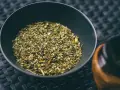 Suszone liście yerba mate w czarnej miseczce, gotowe do zaparzenia. To naturalny napój pobudzający.