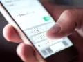 Palec pisze na klawiaturze telefonu: "Już w drodze na wesele!". Potwierdzenie przybycia na wesele sms.