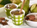 Due tazze con **marmellata di pere** fatta in casa, pere fresche, cannella e zucchero di canna.