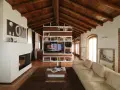 Accogliente soggiorno mansardato con soffitto in legno a vista, camino moderno e libreria centrale. Idee mansarde in legno per un ambiente caldo.