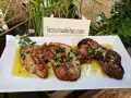 Delicioso hígado de rape a la plancha con ajo y perejil, servido en una bandeja blanca.