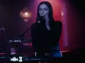 Wokalistka na tle sceny, przygotowująca się do występu na jednym z festiwali muzyki elektronicznej w Polsce.
