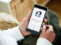 Person använder sin smartphone med BankID-appen för att logga in eller signera.