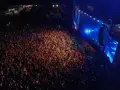 Tłum ludzi na koncercie, rozświetlony sceną i światłami. Atmosfera przed festiwalem Before Festival jest elektryzująca.