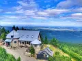 Kamienny schron turystyczny na tle rozległej panoramy Gór Izerskich. Wspaniałe widoki z górskich szlaków.