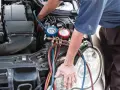 Mechanik sprawdza ciśnienie w układzie klimatyzacji. Zapchany osuszacz klimatyzacji objawy mogą być różne, np. słabe chłodzenie.
