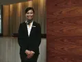 Uśmiechnięta konsjerżka w hotelu, gotowa pomóc. Kto to? To osoba dbająca o komfort gości.