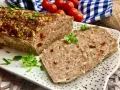 Klasyczna pieczeń rzymska, soczysta i aromatyczna, pokrojona na plastry, ozdobiona natką pietruszki.