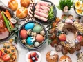 A festive Easter feast in Europe, featuring a glazed ham, colorful eggs, sweet breads, and a decorated cake.