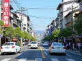 Jaki ruch jest w Japonii? Ulica w Kioto z samochodami, pieszymi i tradycyjną architekturą.