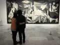 Para ogląda słynne **guernica obraz** Picassa, pełne bólu i chaosu.