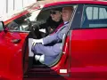 Elon Musk i Donald Trump siedzą w czerwonym samochodzie Tesla.