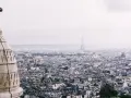 Vista panorámica de París con la Torre Eiffel al fondo. La arquitectura de la ciudad evoca un sentimiento de "enchanté significado".