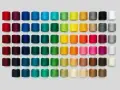 Una gran variedad de tipos de hilos de coser en carretes, organizados por color en filas y columnas.