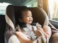 Glückliches Kleinkind im Kindersitz, bereit für eine Fahrt. Ein reboarder test zeigt, wie sicher es ist.