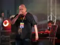 Kazik Staszewski śpiewa na koncercie, ubrany w czarną koszulkę z napisem "Kwartet Pro Forma" i identyfikatorem "Zespół KULT".