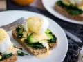 Pyszne jajka po florencku na tostach z awokado i szpinakiem, polane sosem holenderskim. Idealne na brunch!